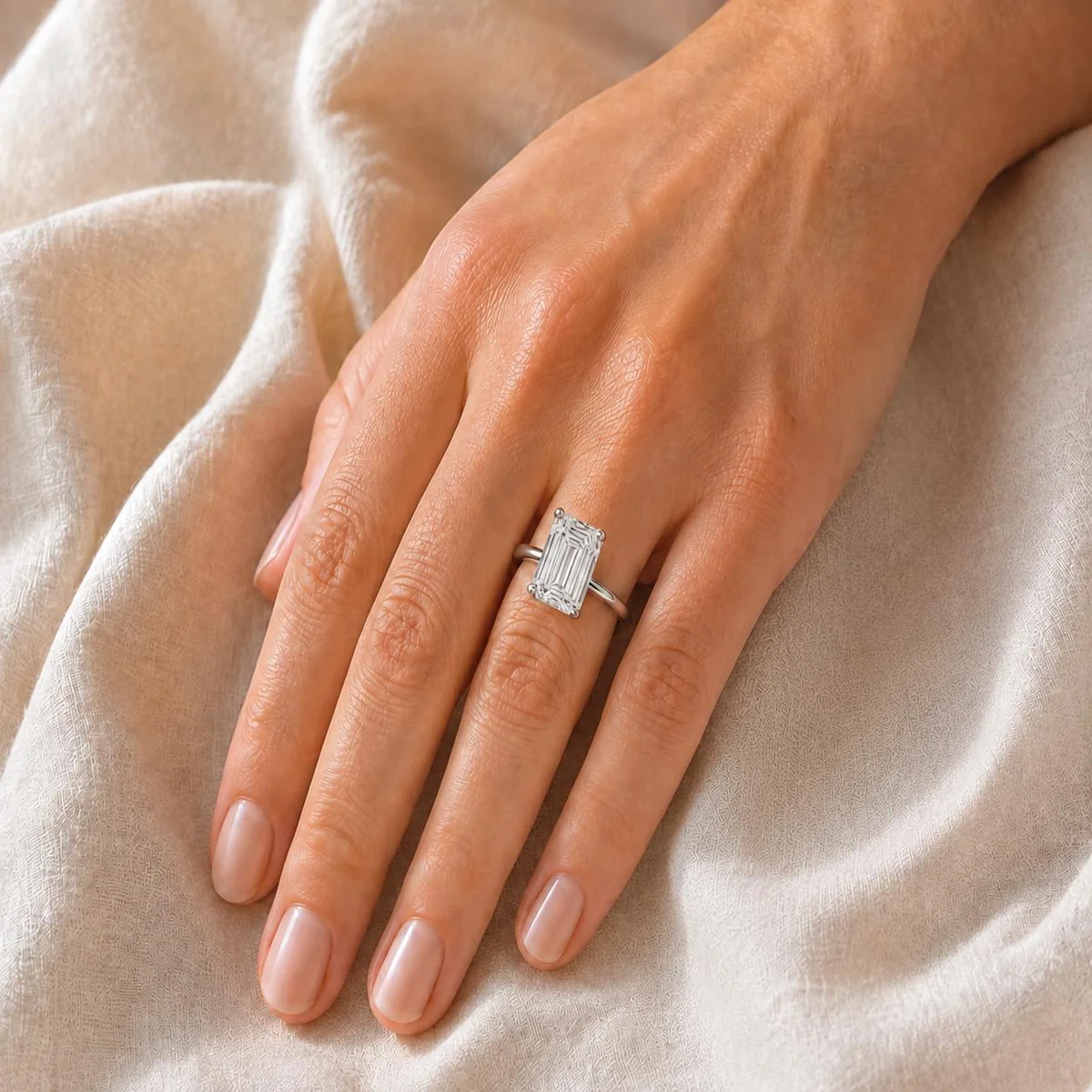 Bague Signature Emerald Solitaire en or blanc, portée à la main