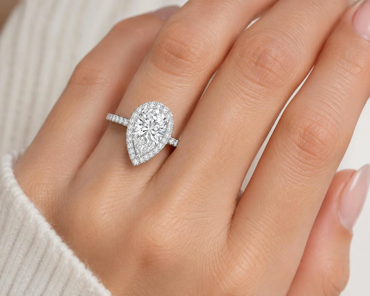 Bague Solara Pear Halo en or blanc, portée à la main